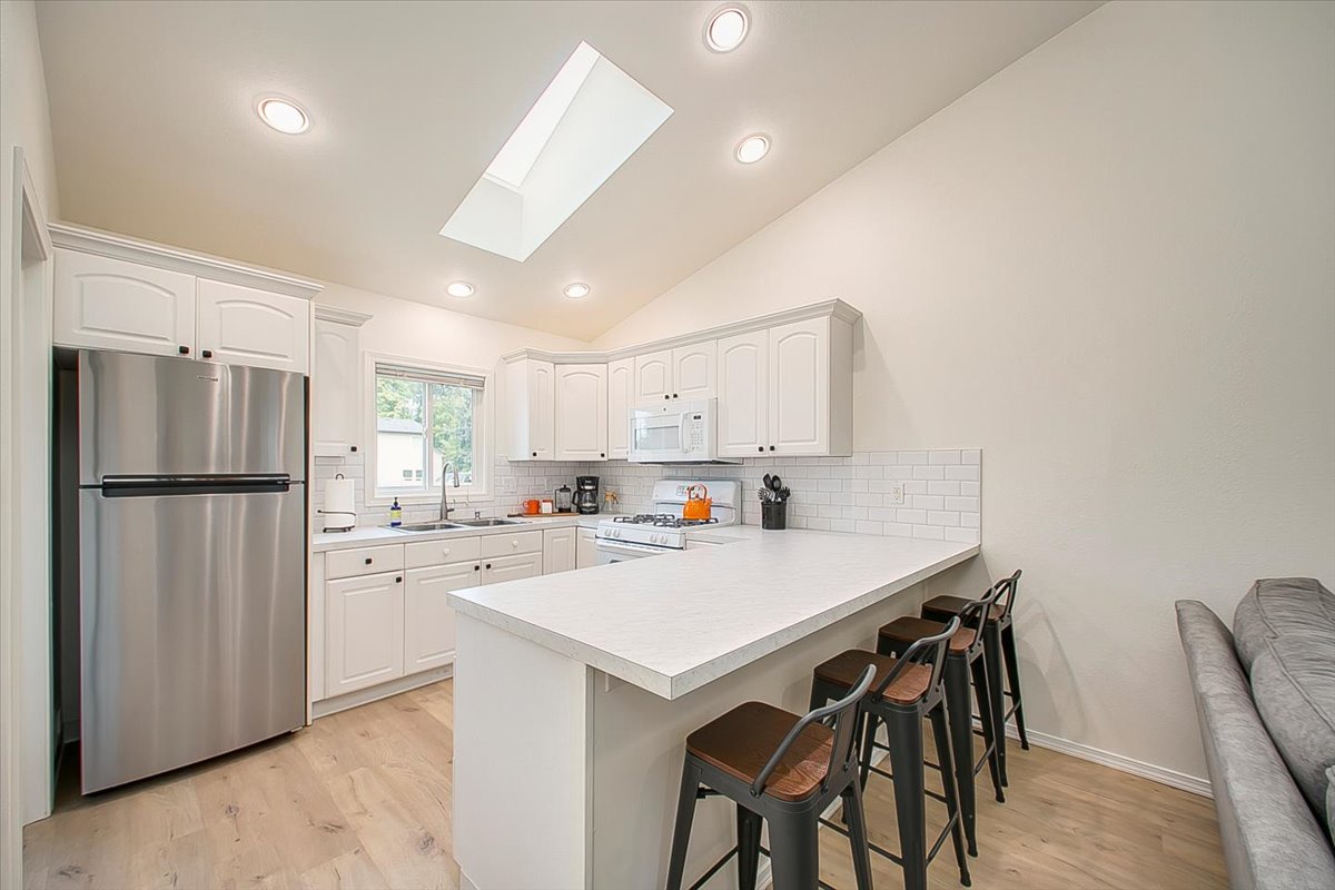 Your bright, open kitchen awaits with modern appliances, spacious island seating, and natural skylight flooding the space with warmth.