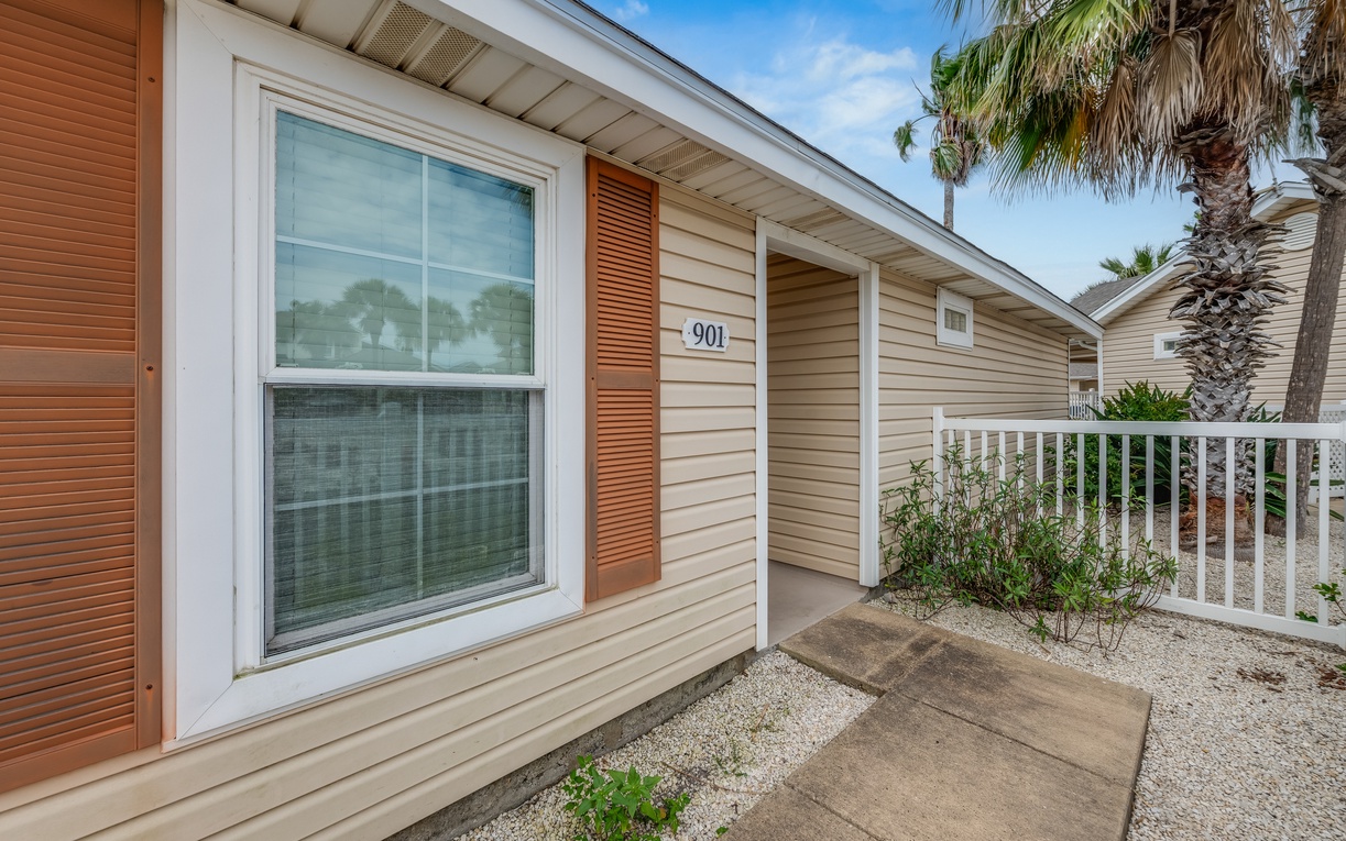 A charming coastal rental with tropical palm trees and clear unit numbering for easy arrival.