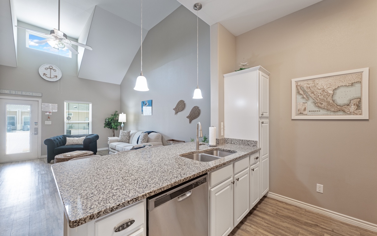 Prepare your favorite meals in this bright, modern kitchen with granite countertops and stainless appliances, overlooking your cozy living space.