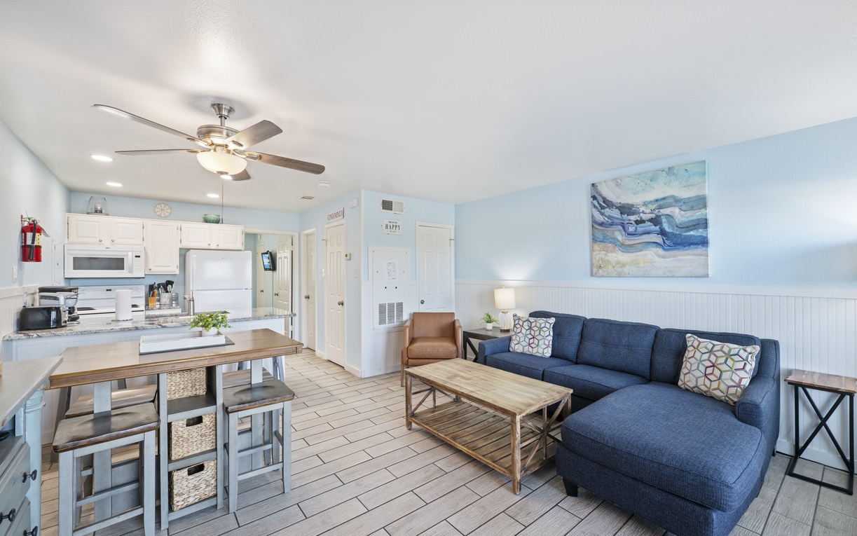 Unwind in your coastal-inspired living space where soft blue tones and ocean artwork create the perfect beachside retreat atmosphere.