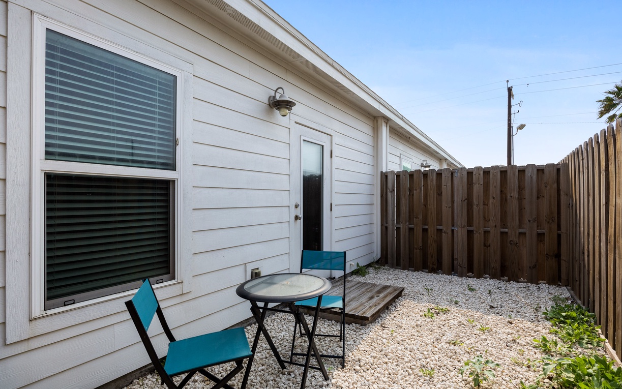 Step onto your private patio where turquoise chairs invite you to sip morning coffee in the peaceful, fenced backyard.