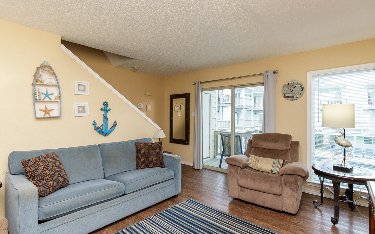 Sink into the comfortable sofa and armchair in your coastal-themed living room, where nautical touches create a relaxing seaside vibe for your getaway.