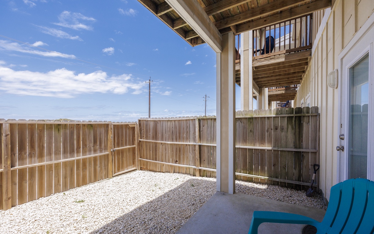 Step onto your private patio where blue skies stretch endlessly above weathered wood railings and gravel grounds.