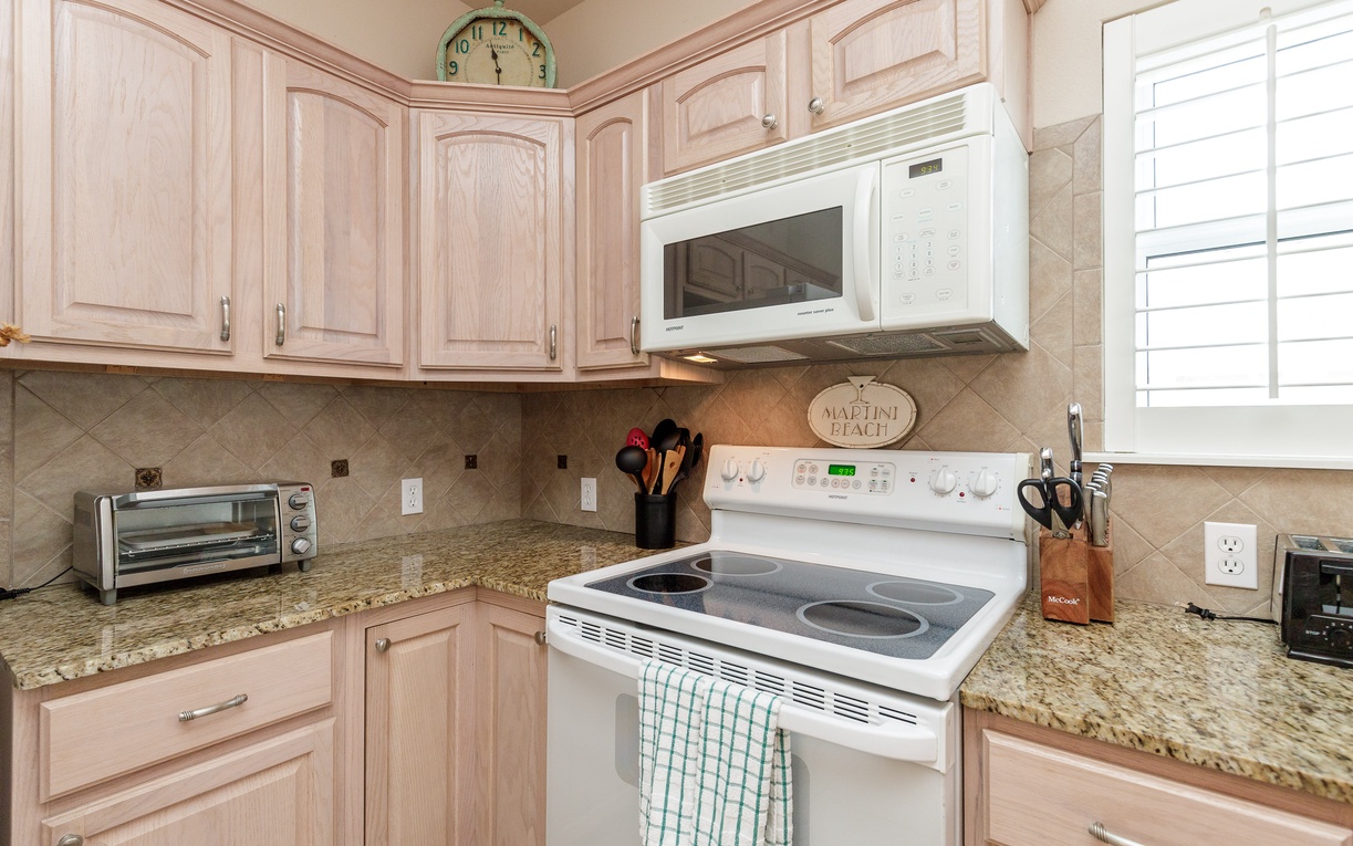 Your fully-equipped kitchen features granite counters, white appliances, and charming coastal touches—perfect for preparing meals during your stay.