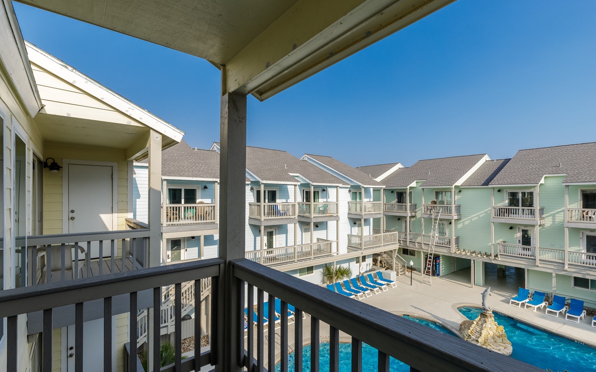 Relax on your primary bedroom balcony overlooking the sparkling pool and courtyard