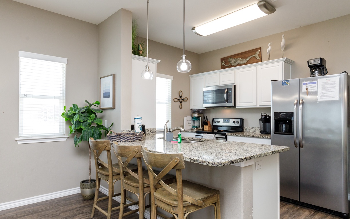 Your fully equipped kitchen features granite countertops, stainless steel appliances, and a breakfast bar perfect for morning coffee or casual meals.