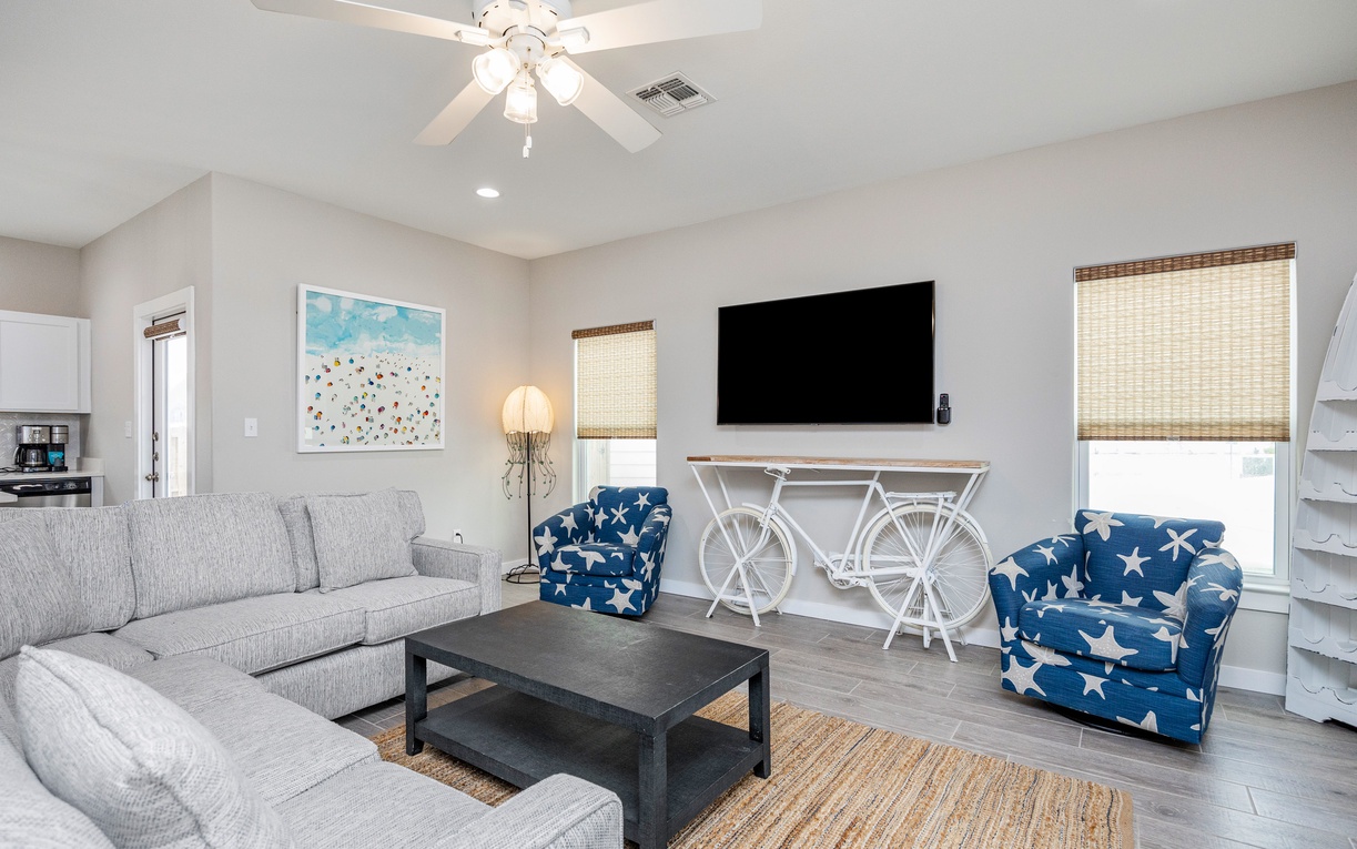 Relax in your bright living room with plush seating, unique bicycle console, and coastal charm.