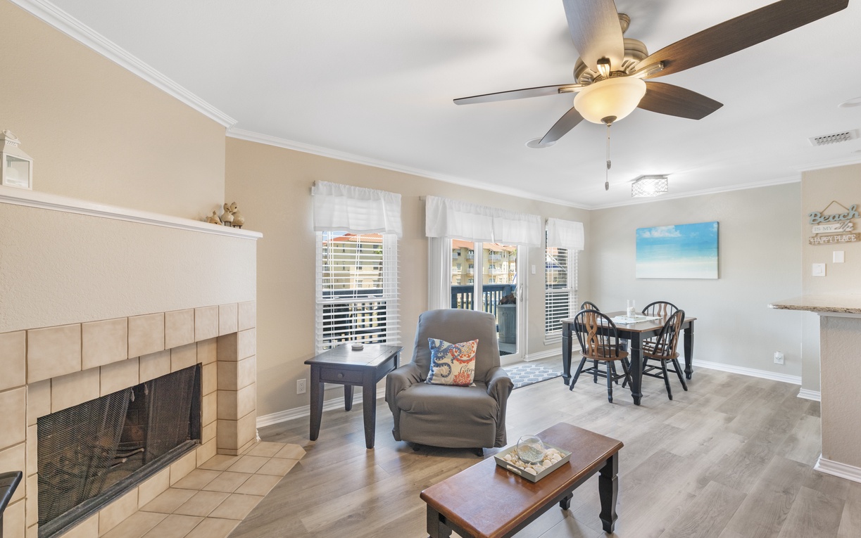 Relax in your comfortable living area with cozy fireplace, ceiling fan, and dining space perfect for memorable meals together.