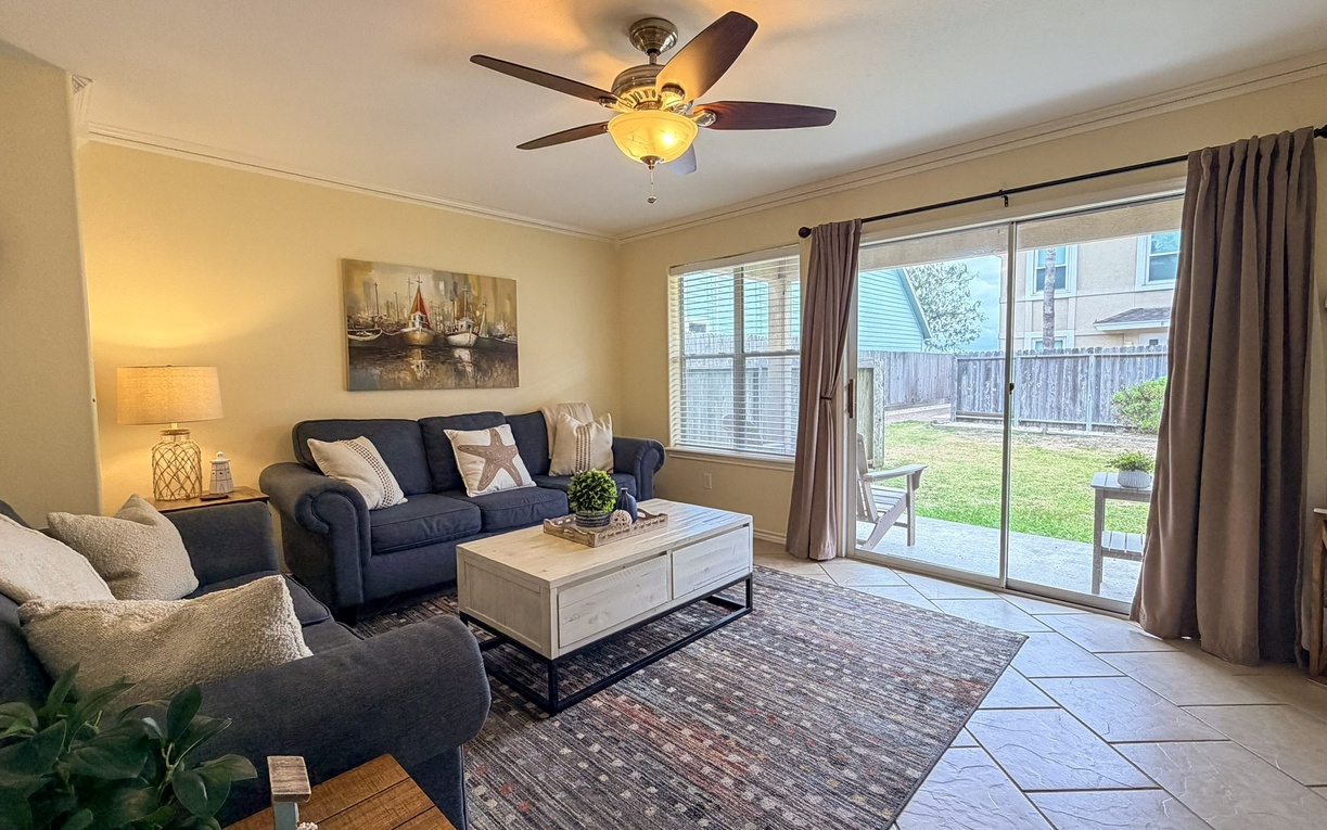 Settle into your comfortable living room with plush seating, where the ceiling fan keeps you cool while you enjoy views of the private backyard.