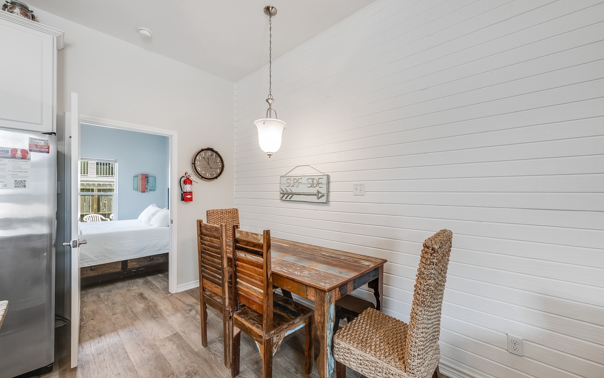Your cozy dining nook features a rustic wooden table perfect for morning coffee or intimate meals, surrounded by charming shiplap walls.