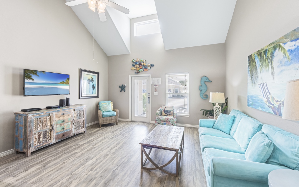 Sink into coastal comfort where ocean-themed artwork and soft turquoise furnishings create your perfect beachside retreat.