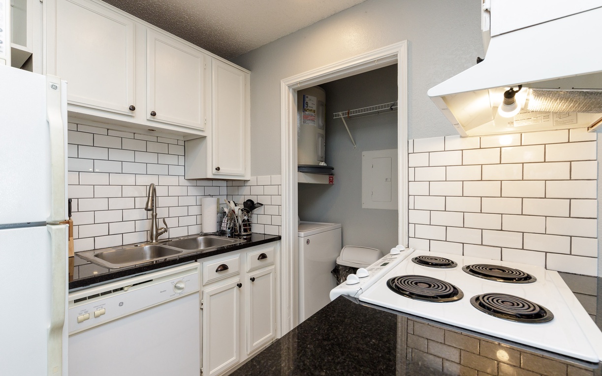 Your fully-equipped kitchen features crisp white cabinetry, classic subway tile backsplash, and everything needed to prepare home-cooked meals during your stay.