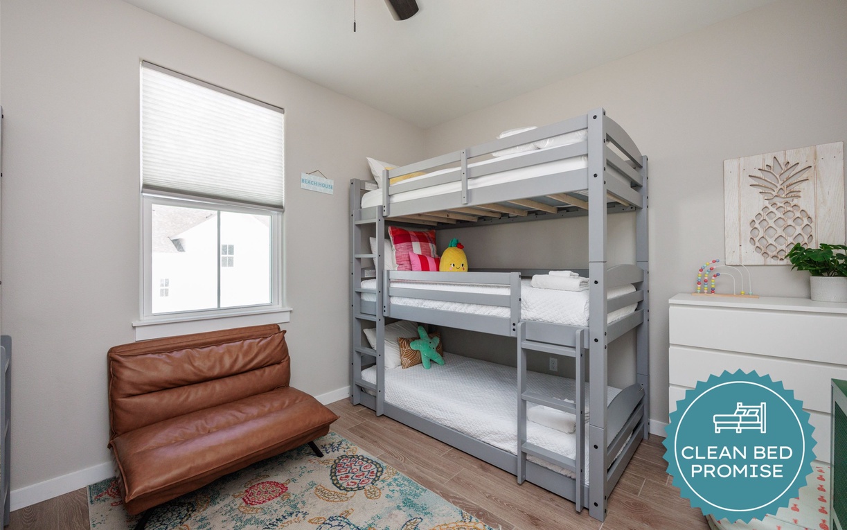 Your kids will love this cheerful bedroom featuring comfortable bunk beds and a cozy leather chair for bedtime stories.