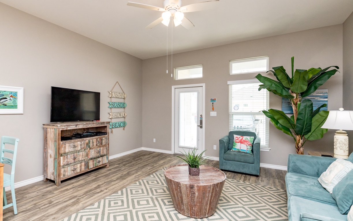 Relax in your stylish living space with coastal-themed decor, comfy seating, and a large TV for your entertainment.