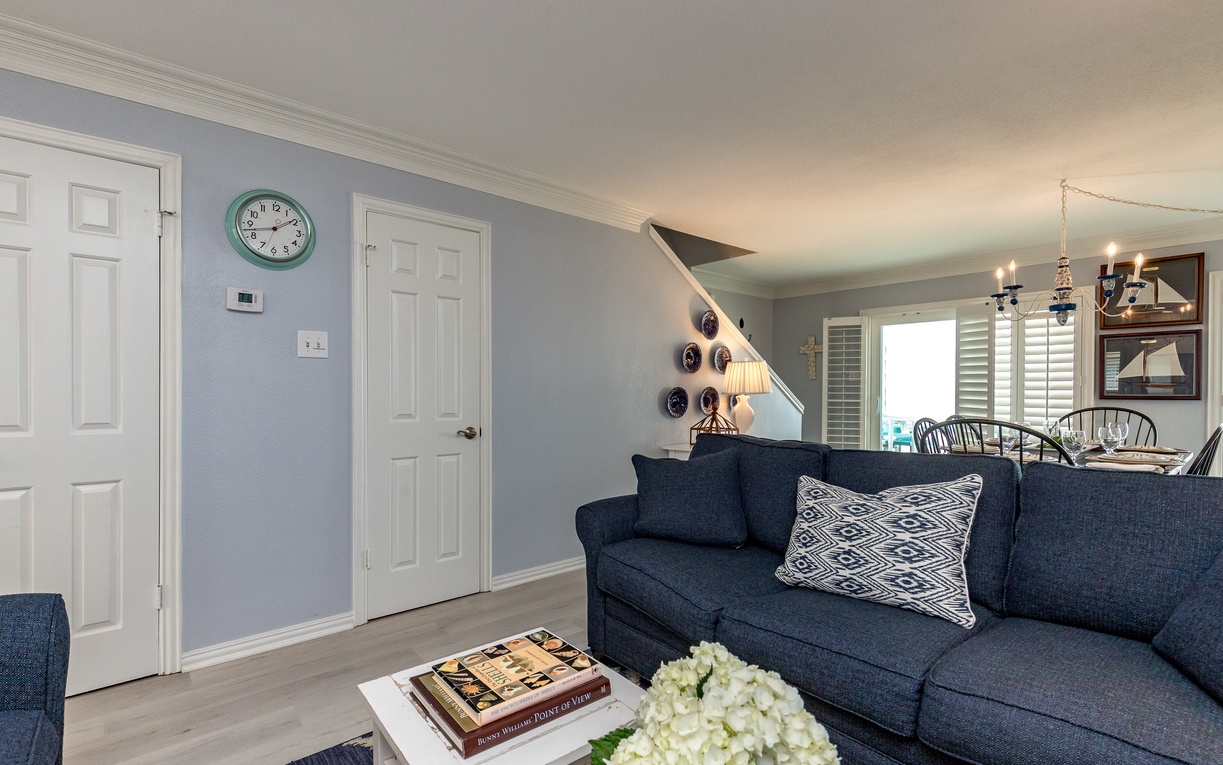Relax in your stylish living room with coastal charm, featuring a plush navy sofa and nautical touches that create the perfect seaside retreat.
