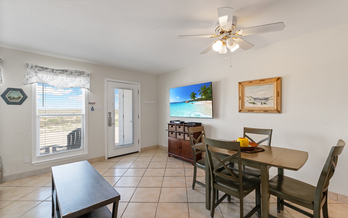 Your bright dining area features coastal charm with a perfect table for meals and glimpses of the sea through your window.