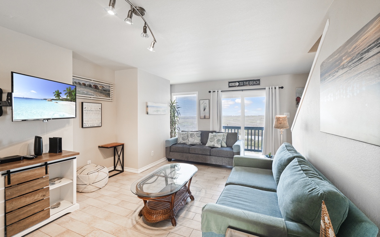 Relax in your bright, beach-themed living space with comfy seating and coastal charm welcoming you home after sunny adventures.