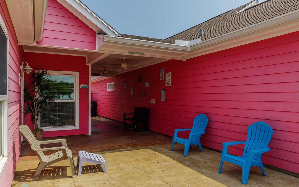 Relax in your private covered patio with colorful seating and tropical touches, perfect for morning coffee or evening conversations.