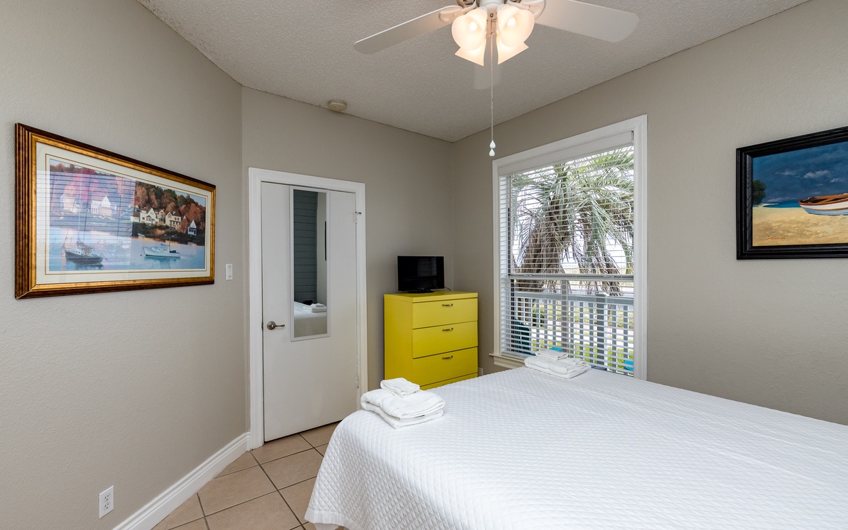 Your bright bedroom features crisp linens, tropical views, and a cheerful yellow dresser for storing your vacation essentials.