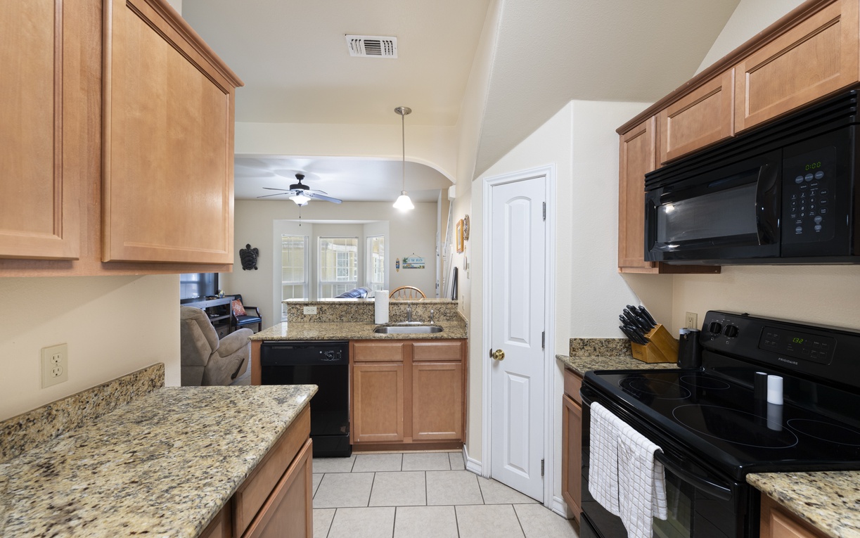 Your fully equipped kitchen with granite counters and modern appliances makes meal prep a breeze, with open views into the living area for easy conversation.