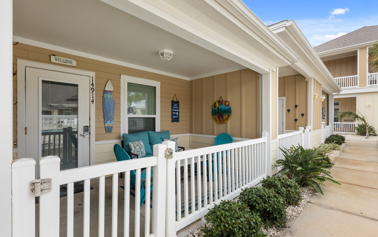 Your covered porch welcomes you with coastal charm, featuring comfy seating where you can unwind and soak up the beachy vibes.