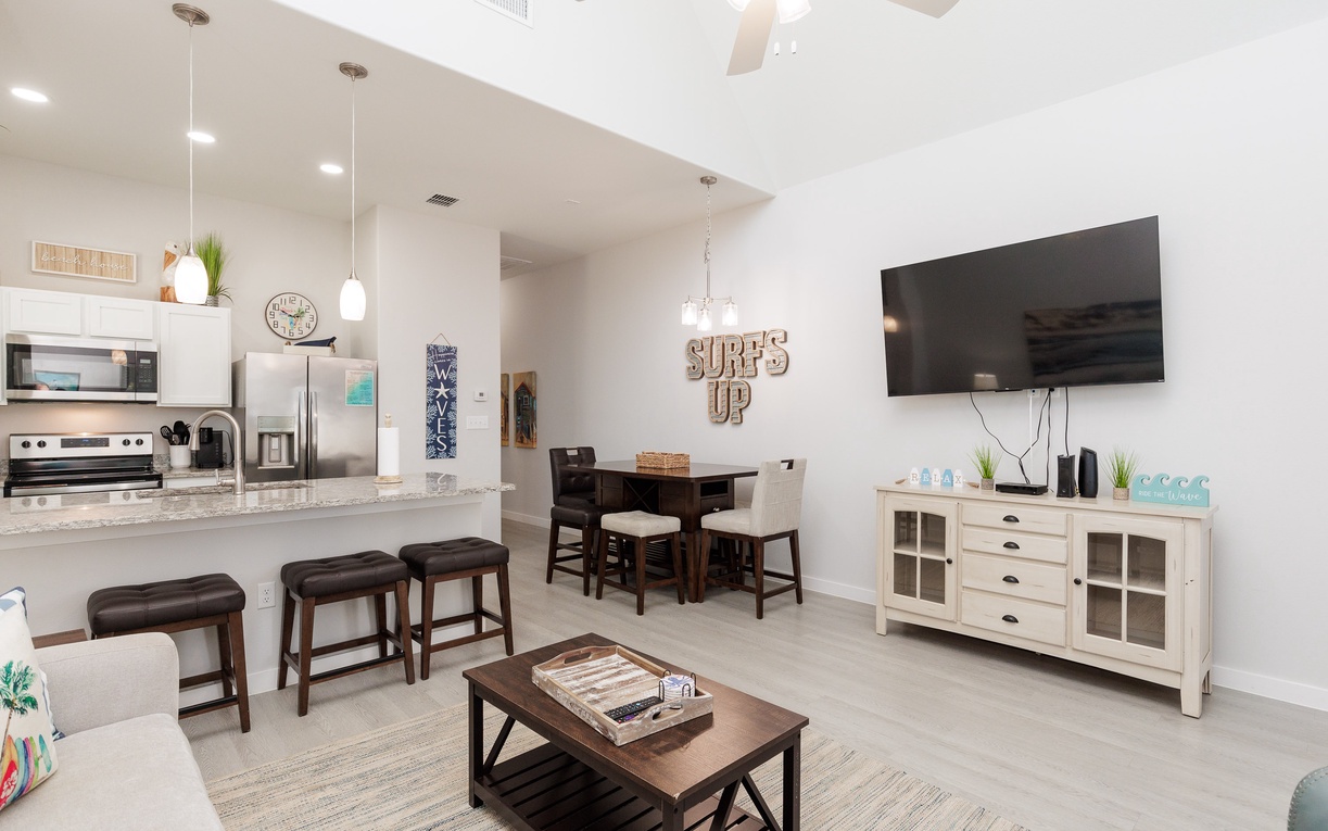 Relax in your bright, modern open-concept space featuring a fully equipped kitchen, cozy dining area, and entertainment center perfect for unwinding.
