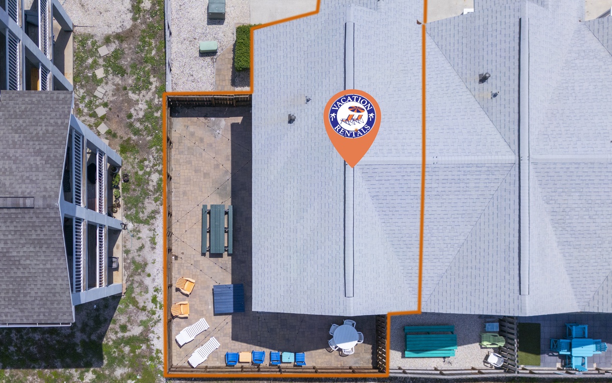 Aerial view of this modern vacation rental property showcasing the distinctive roofline and outdoor amenities in the surrounding residential area.
