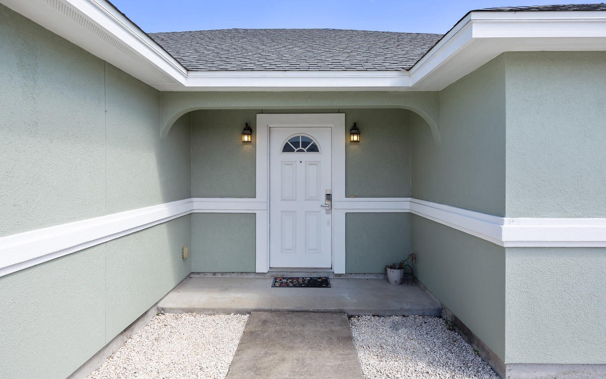 Clean, welcoming entrance with charming architectural details and warm lighting fixtures marks your arrival at this comfortable retreat.