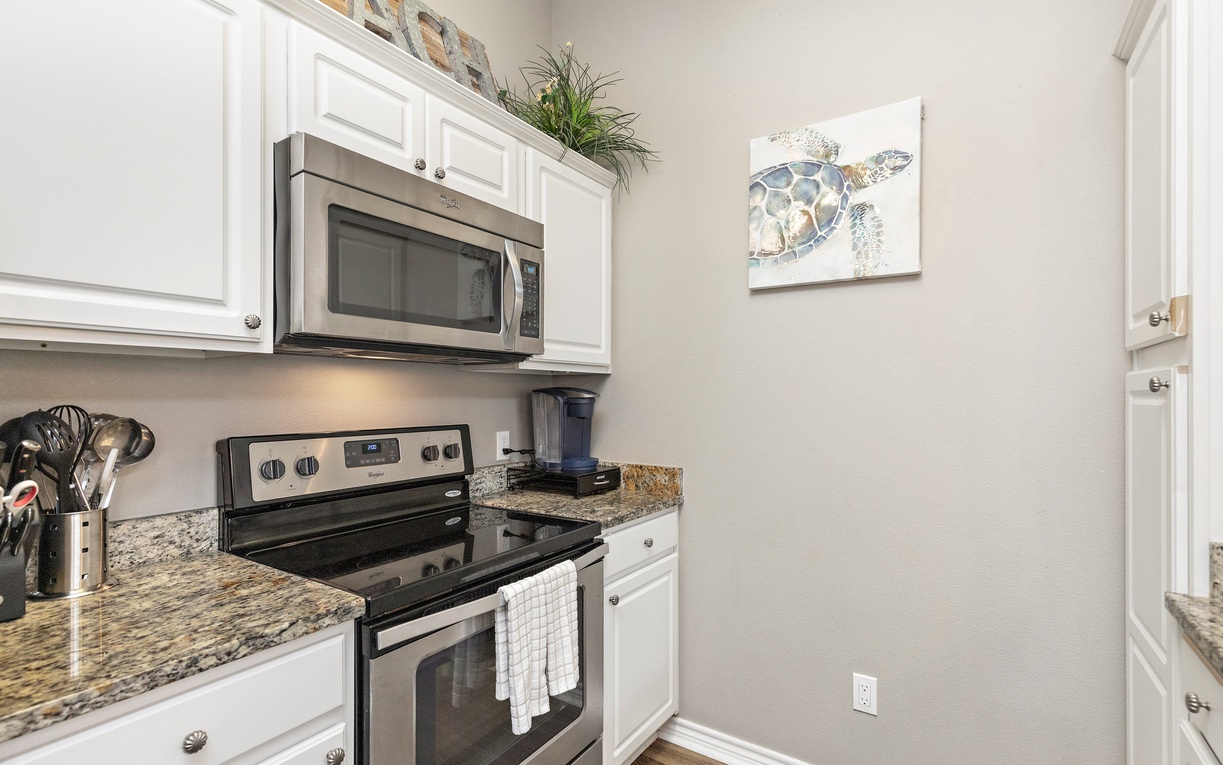 Cook your favorite meals in your fully equipped kitchen featuring granite counters, stainless appliances, and charming coastal artwork.