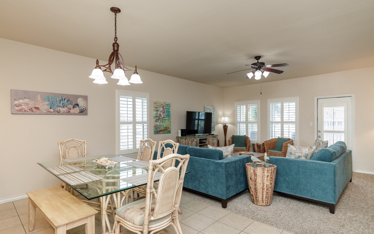 Your bright, open living space features comfortable teal seating and coastal decor, perfect for relaxing after beach days.
