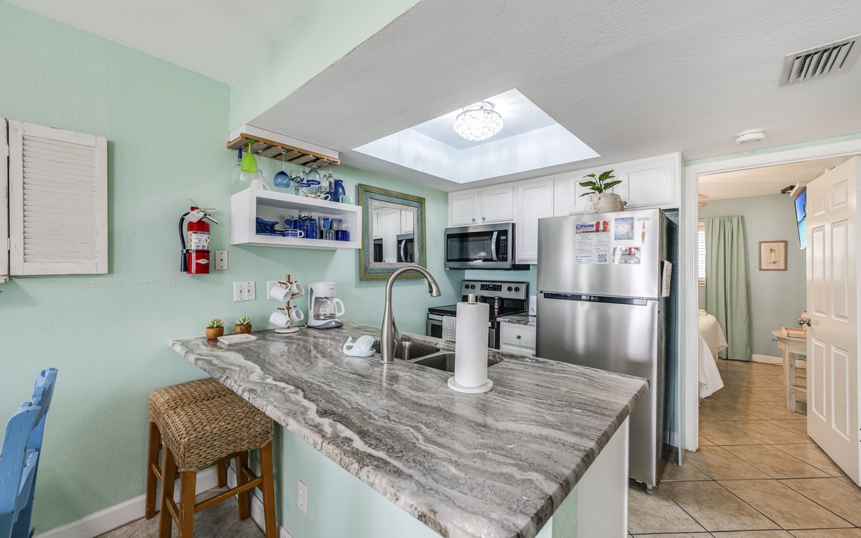 Prepare meals in your bright kitchen featuring granite countertops, stainless steel appliances, and a charming skylight that fills the space with natural light.