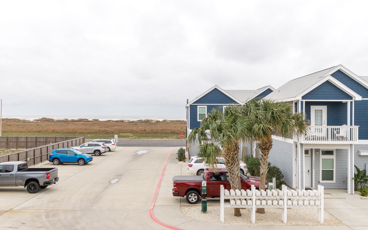 Coastal vacation rental with convenient parking and palm-lined surroundings near natural marshlands.