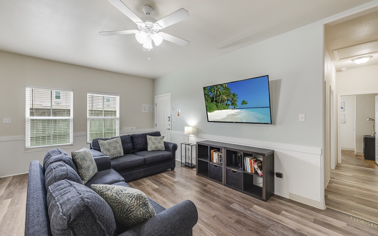 Sink into comfortable seating and unwind with your favorite shows on the large TV in this bright, airy living room.