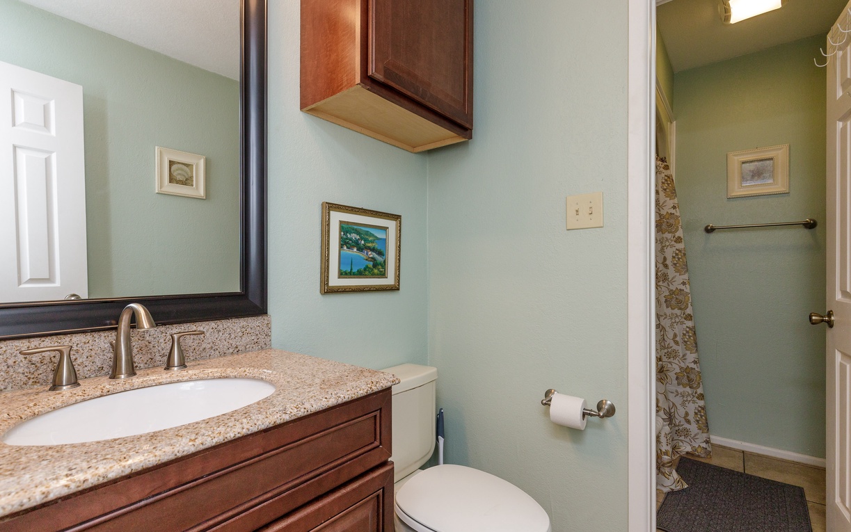 Freshen up in this elegant bathroom with granite countertops, rich wood cabinetry, and thoughtful touches that make your stay feel special.