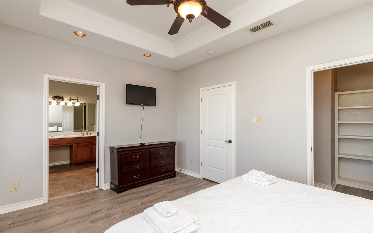 Rest peacefully in your spacious bedroom with elegant ceiling fan, flat-screen TV, and convenient en-suite bathroom access.
