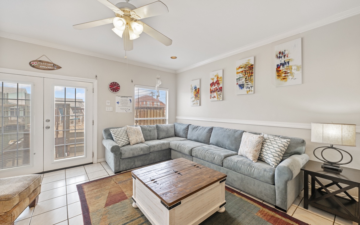 Relax on your spacious sectional sofa while enjoying natural light streaming through glass doors leading to your private outdoor space.