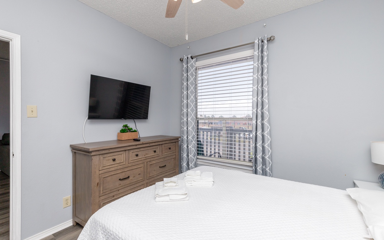 Drift off in your peaceful bedroom with city views, where soft gray walls and comfortable furnishings create the perfect retreat.
