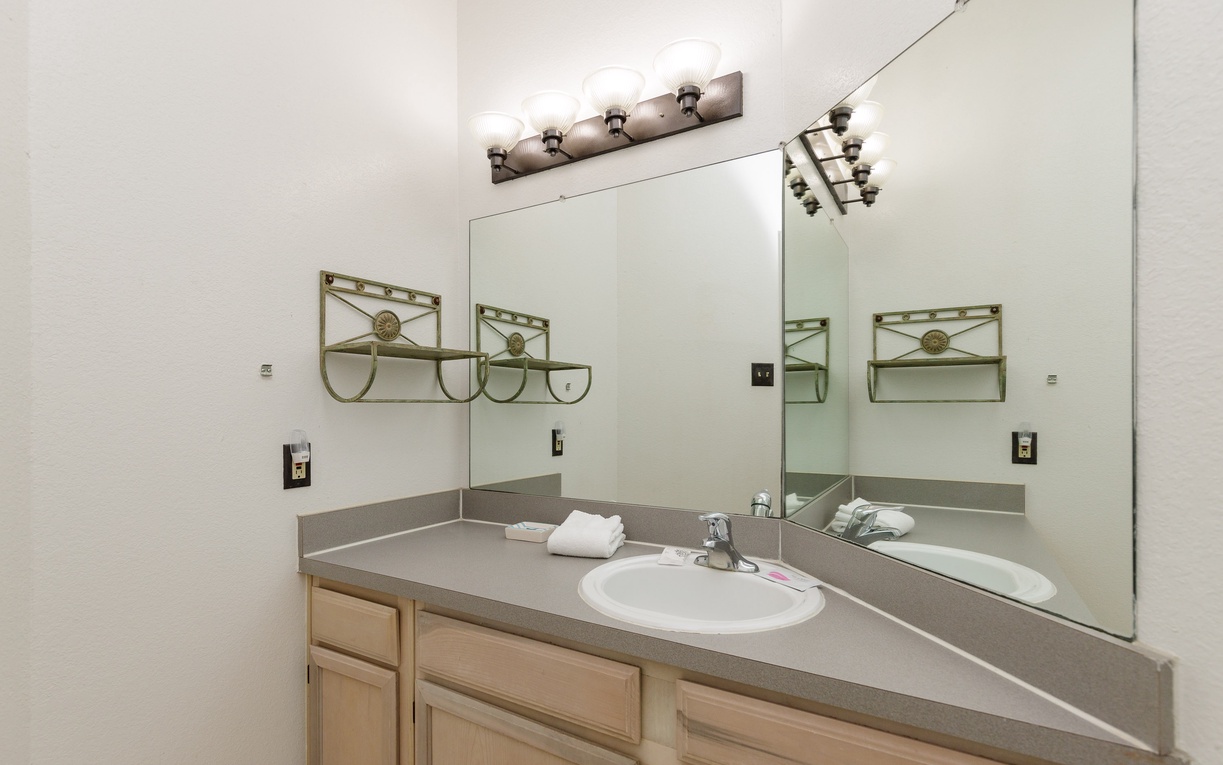 Your private bathroom features a spacious vanity with ample storage, fresh towels, and thoughtful lighting for your morning routine.