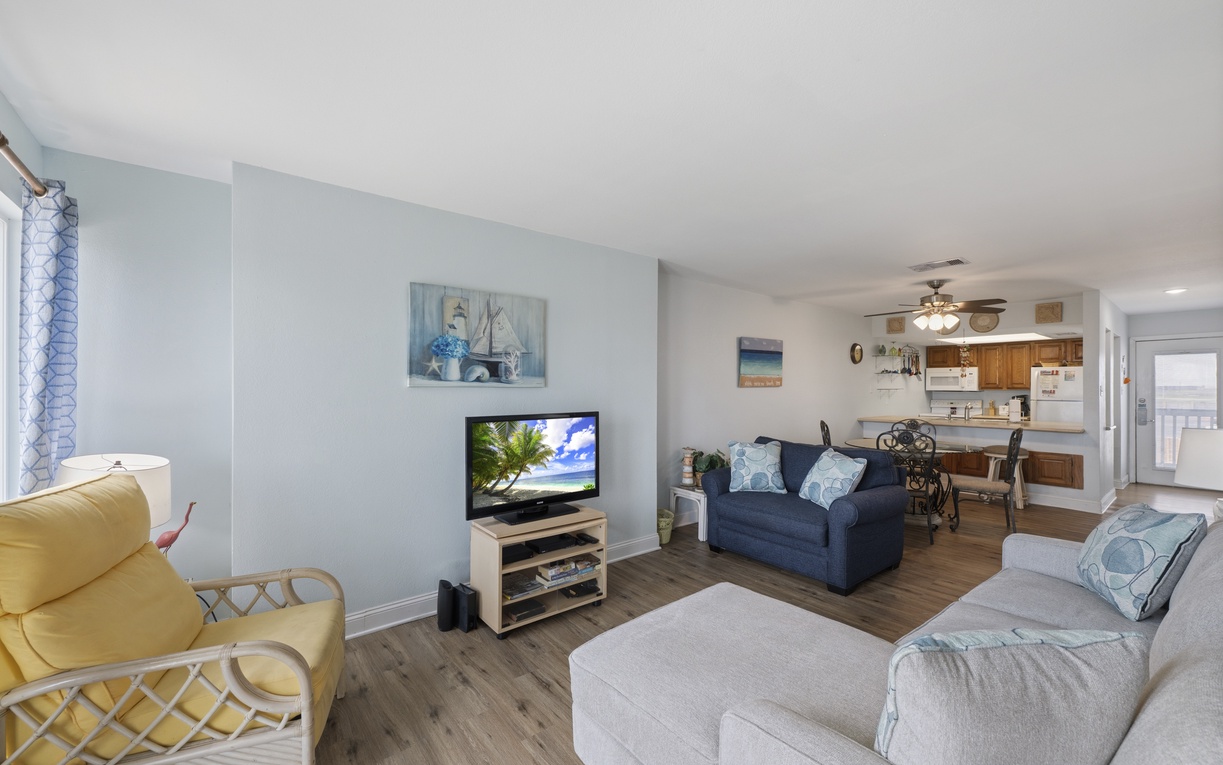 Sink into coastal comfort in your open living space, complete with plush seating, beach-inspired décor, and a smart TV for cozy evenings.