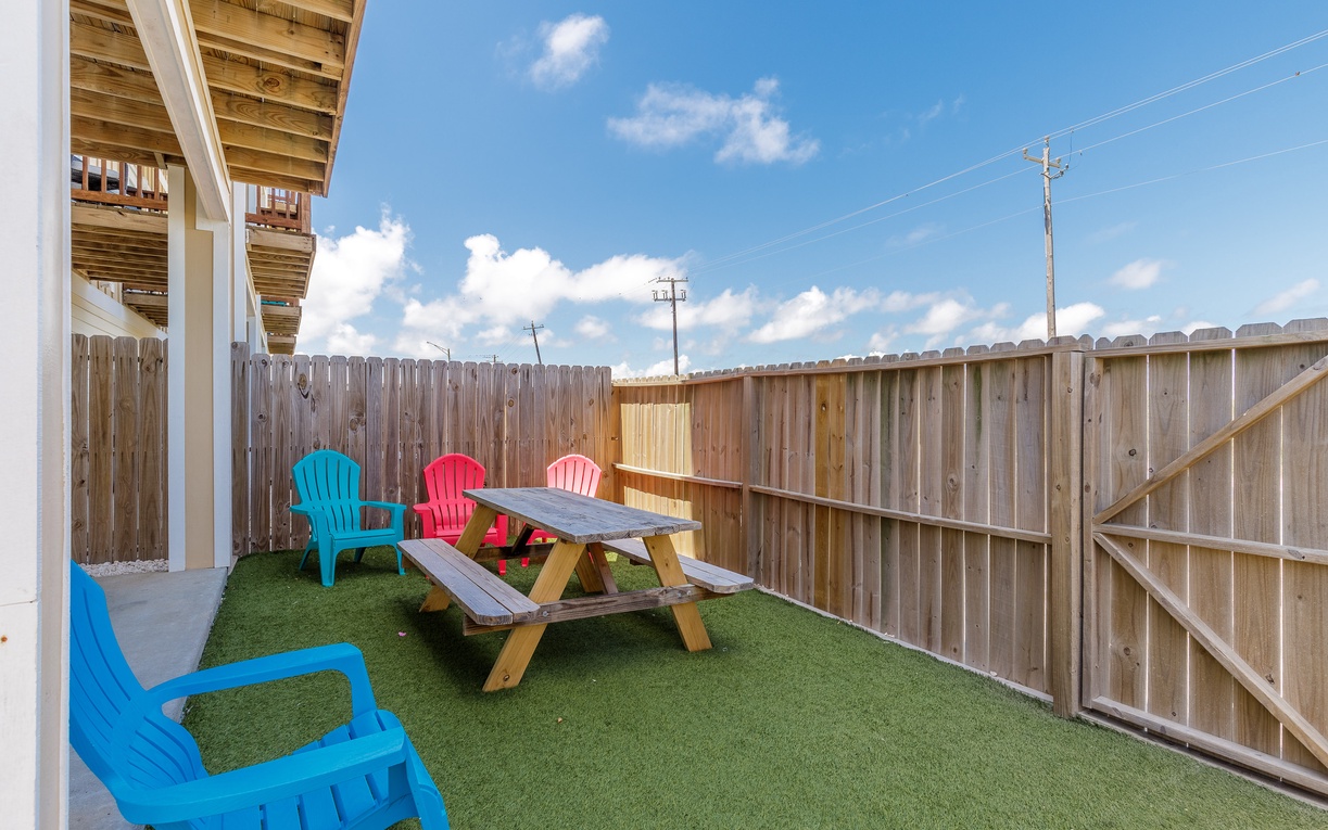 Your private backyard oasis awaits with colorful seating and a perfect picnic spot for morning coffee or evening gatherings.