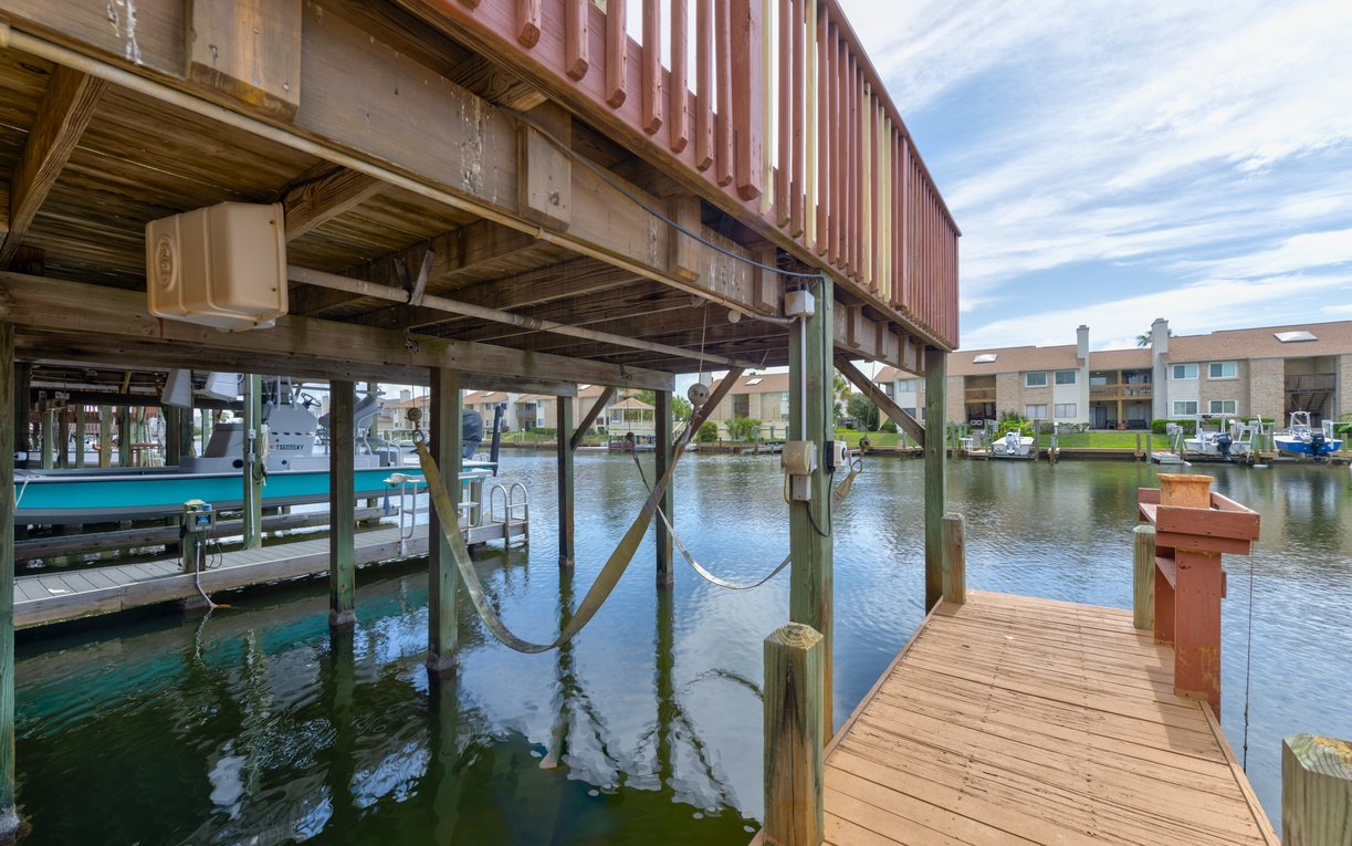 Private fishing dock on a calm canal, offering direct water access and views of the surrounding neighborhood - No boat slip available.