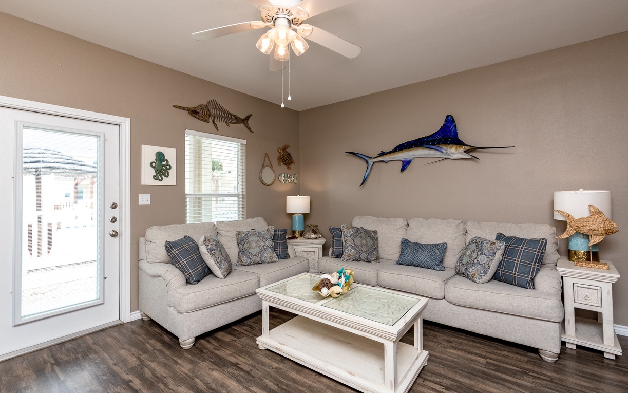 Relax in this coastal-themed living room where plush sectional seating and ocean-inspired decor create your perfect retreat for unwinding after beach days.