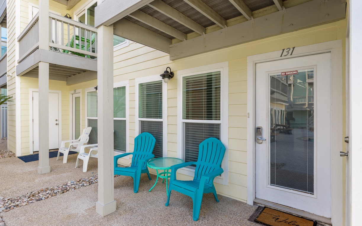 Settle into your private patio with bright turquoise chairs and a side table - your perfect spot for morning coffee.
