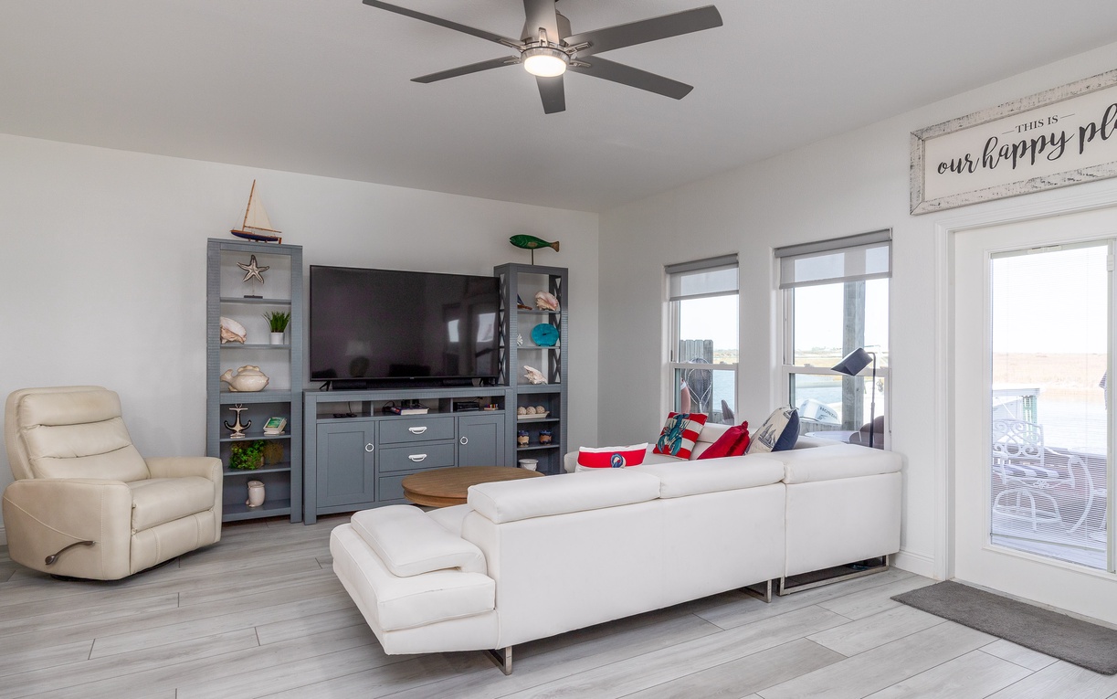 Sink into plush white sofas and enjoy movie nights in your bright, modern living space with entertainment center and city views.