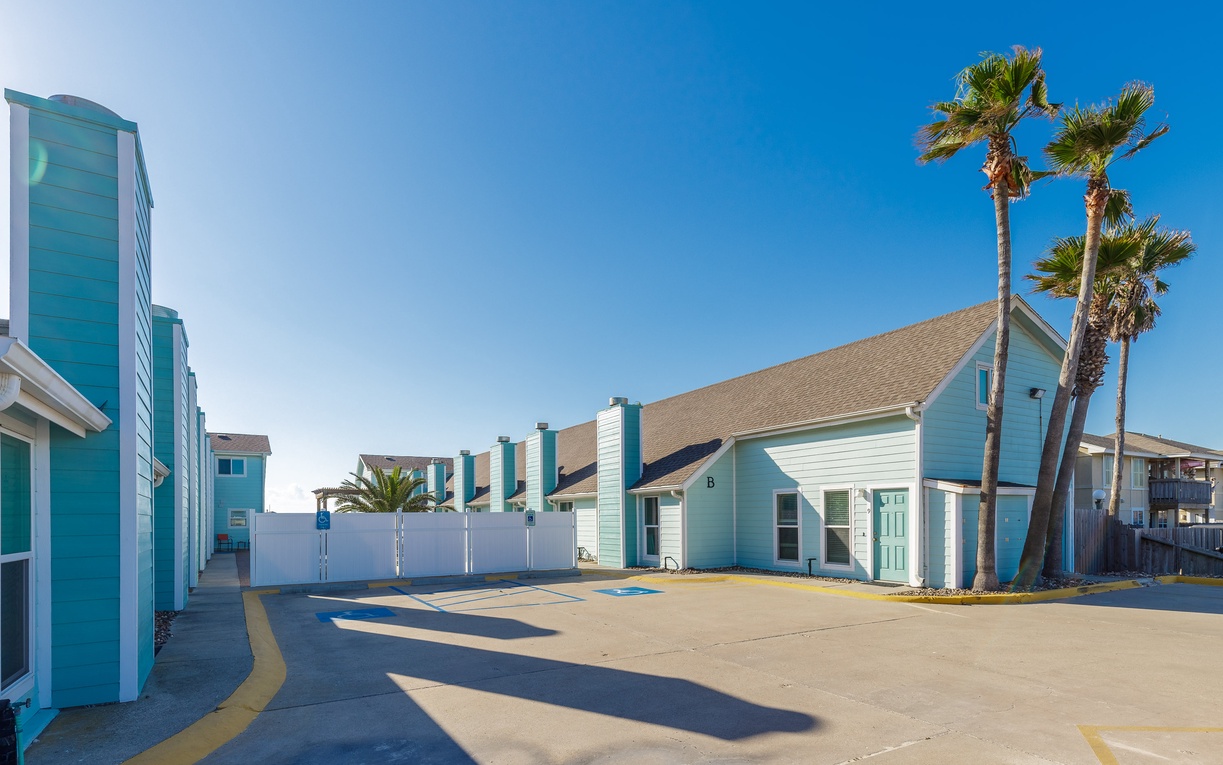 Charming coastal-style complex with cheerful blue exteriors and swaying palm trees create a perfect waterfront retreat.