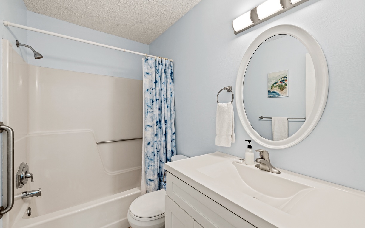 Your private bathroom features a clean, coastal design with a soaking tub and refreshing shower. Soft blue tones and fresh towels create a soothing retreat after your day.