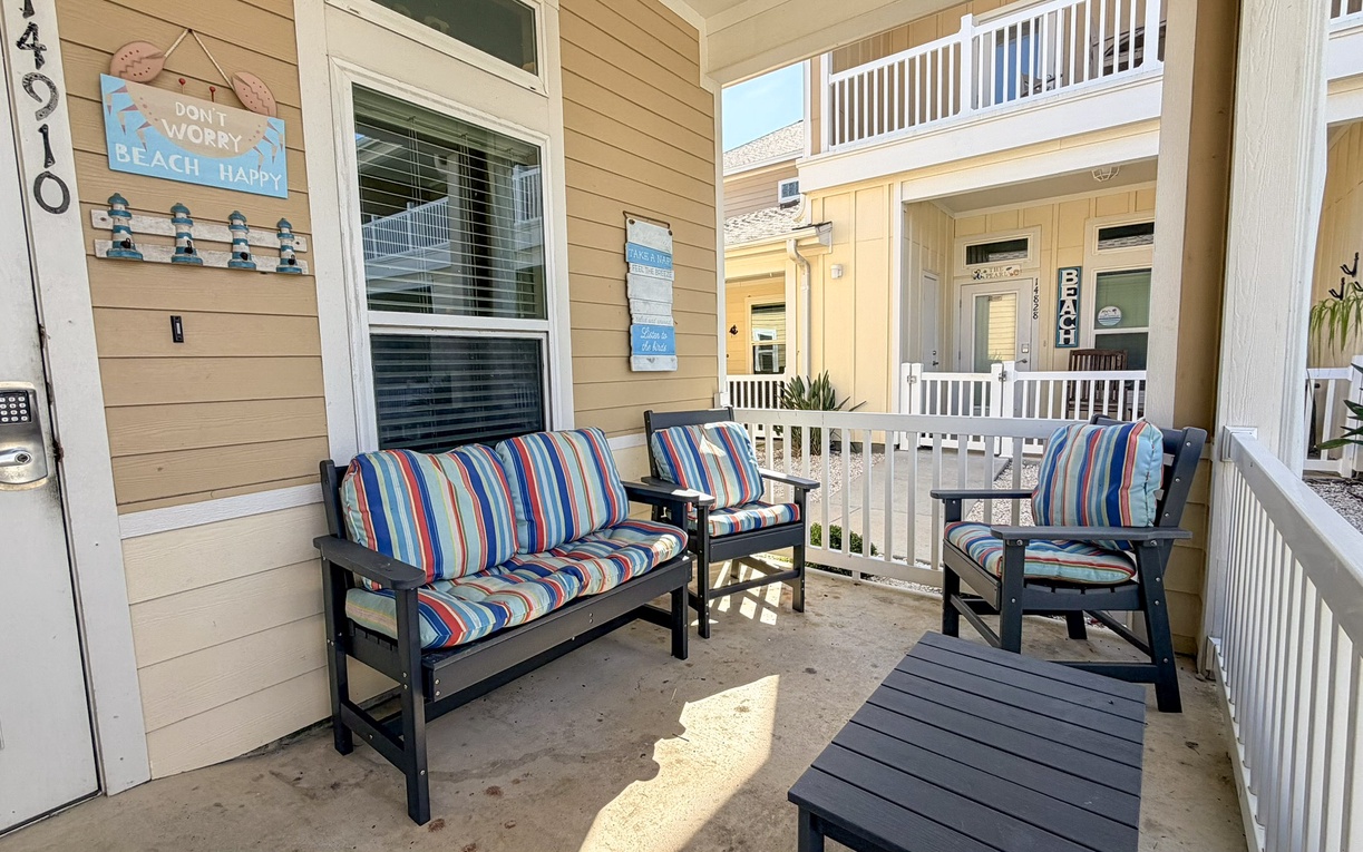 Your private porch welcomes you with colorful striped cushions and patio seating, perfect for morning coffee or evening relaxation.