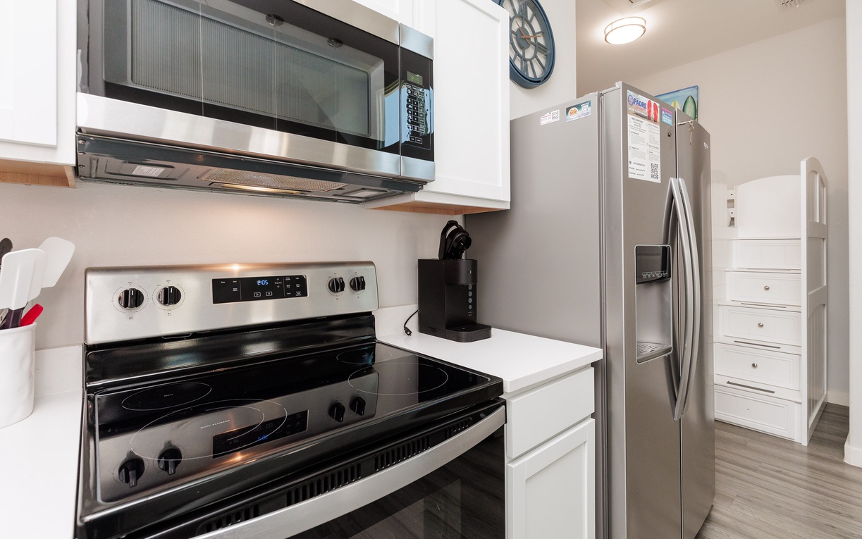 Your fully equipped kitchen features stainless steel appliances, including a spacious refrigerator, microwave, and stove for all your culinary needs.