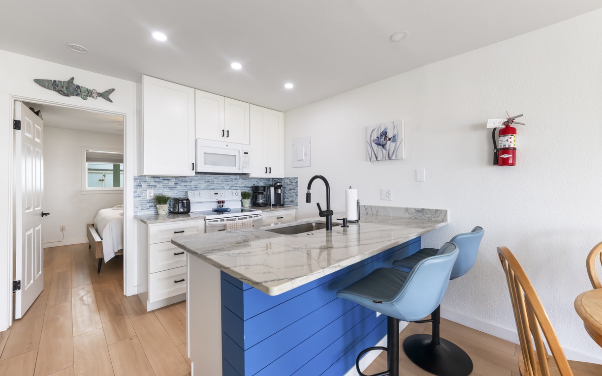 Your bright, modern kitchen comes fully equipped with everything you need to prepare meals at home. Enjoy morning coffee at the island bar, then step into the adjoining bedroom for a peaceful retreat.