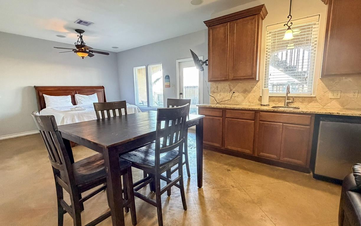 Relax in your open-concept space where modern kitchen flows into cozy dining area, with comfortable bed just steps away for ultimate convenience.